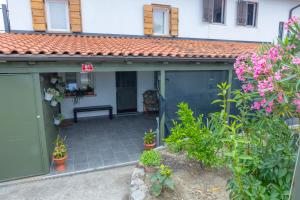 a green garage with a bench and some plants at APARTMA BrdonKA in Dobrovo