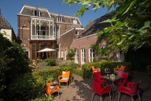 um pátio com cadeiras e uma mesa em frente a um edifício em Boutique Hotel De Blauwe Pauw em Den Bosch