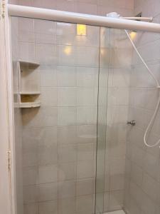 a shower with a glass door in a bathroom at Ap 2 Quartos em Caiobá, garagem, Wi-Fi in Matinhos