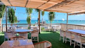 a restaurant with tables and chairs on the beach at Hotel Bloom Garden Beach Punta Cana in Punta Cana