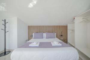 a bedroom with a large white bed with two towels at Principado de Aracena I in Aracena