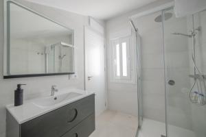 a white bathroom with a sink and a shower at Principado de Aracena I in Aracena