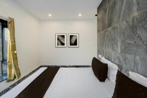 a bed in a room with a stone wall at Hotel O Dream Vegas in Hyderabad