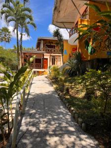 a walkway in front of a house with palm trees at Hosteria Chuquitos - Chalupas in Tena