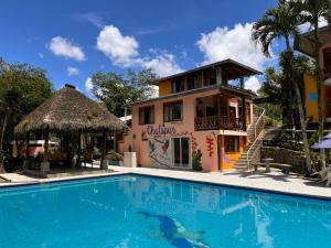 a villa with a swimming pool in front of a house at Hosteria Chuquitos - Chalupas in Tena
