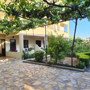 a house with a stone walkway in front of a building at Kypsel Apartment in Durrës