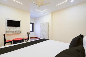 a bedroom with a bed and a table and chairs at Hotel O Swarg Paradise Inn in Rānchī
