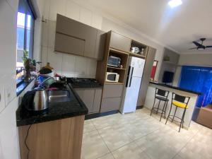 a kitchen with a sink and a refrigerator at Casa da tami in Bonito