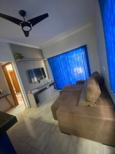 a living room with a couch and blue curtains at Casa da tami in Bonito