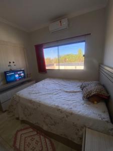 a bedroom with a large bed with a window at Casa da tami in Bonito