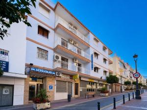 a large white building with balconies on a street at Sun Serramar Boutique Hostal in Benalmádena