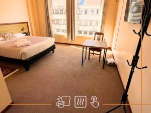 a bedroom with a bed and a table and a window at Noth Central in Osorno