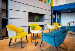 a group of chairs and tables in a lobby at Holiday Inn Mulhouse by IHG in Mulhouse