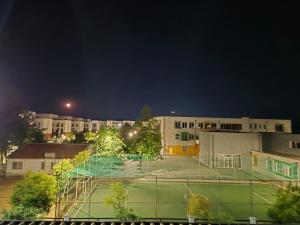 a tennis court in front of a building at night at FloVa Apartment in Valjiosi