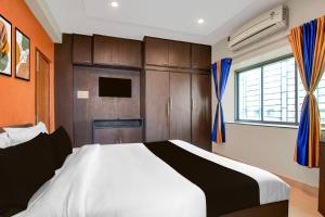 a bedroom with a large bed and a window at Hotel O Newtown worldstay in Thākurdwari