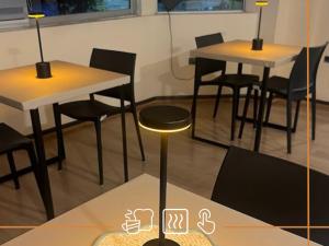 a room with two tables and chairs and lamps at Noth Central in Osorno