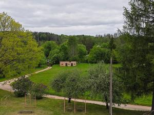 a building in the middle of a field with trees at Līgatne Forest View Apartament in Skalupji