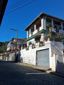 a white building with a garage on a street at LOFT da Serra Imperial in Petrópolis