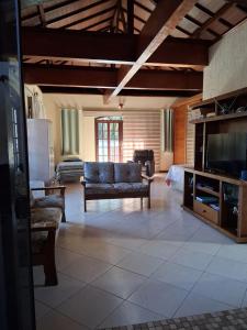 a living room with a couch and a flat screen tv at LOFT da Serra Imperial in Petrópolis
