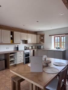 a kitchen with a wooden table in a kitchen at The Barn With A View in Portskewett