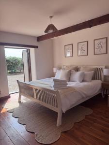 a large white bed in a room with a window at The Barn With A View in Portskewett +13 photos