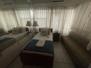 a hotel room with two beds and a couch at Posada Casa Adriana in Puerto Vallarta
