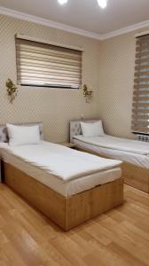 two beds in a room with two windows at Sadaxlı Hotel & Restaurant in Şǝrǝdil