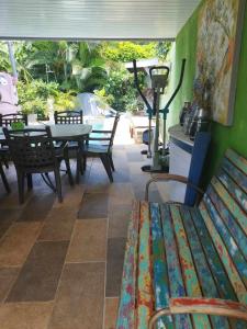 a patio with a table and chairs and a bench at Banian Camping petit déjeuner offert in Bora Bora