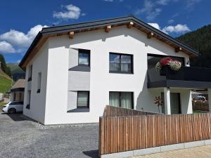 a white house with a fence in front of it at chalet10 in Samnaun