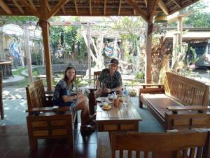 a man and a woman sitting at a table at Sunrise Lodge and Lounge Hotel in Panji
