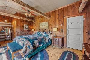 a bedroom with a bed and wooden walls at Pondview Cabin - Rustic Log Style Home, Grill, Wifi, Screen Porch, Trail, View, Pond Access, King Bed in Morton Grove