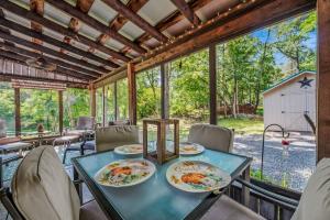 a dining room with a table and chairs and a barn at Pondview Cabin - Rustic Log Style Home, Grill, Wifi, Screen Porch, Trail, View, Pond Access, King Bed in Morton Grove