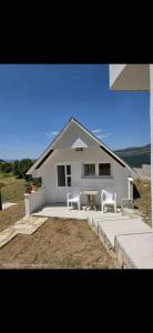 two chairs and a table in front of a house at Jezerina in Šavnik