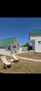 two lounge chairs and a building with a green roof at Jezerina in Šavnik