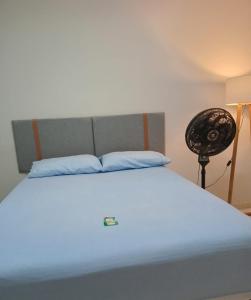 a bedroom with a white bed with a fan at Capsula Residence Hotel in Marília