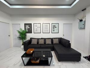 a living room with a black couch and a table at White Villa Lanta in Ko Lanta +6 photos