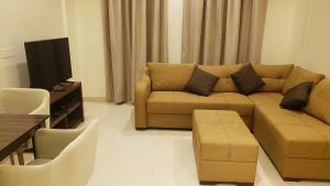 a living room with a couch and a tv at Alzahraa apartment in Salalah