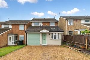 a house with a green garage in a yard at Entire 3 bedroom house in Luton
