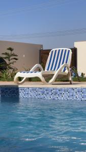 a lounge chair sitting next to a swimming pool at أستراحة الهوني in Banghāzī