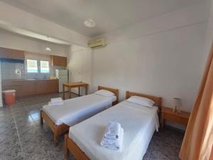 a room with two beds and a kitchen at Triton Sea View Studios in Tsoutsouros +21 photos