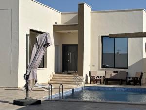 a villa with a swimming pool and a house at أستراحة الهوني in Banghāzī