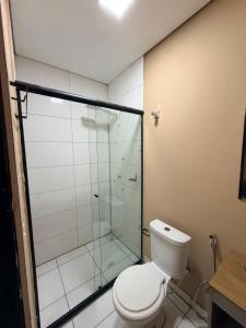 a bathroom with a toilet and a glass shower at Hotel ideal 2 in Inocência +17 photos