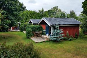 a small red shed with a wooden deck in a yard at B&B Olsegården in Tvååker