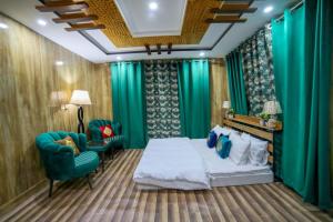 a bedroom with green curtains and a bed and a chair at Royal Brangsa in Skardu