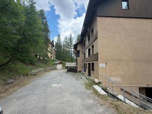 an empty road next to a building with trees at Chalet Puy-Saint-Vincent m from slopes in Puy-Saint-Vincent