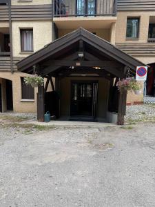 a building with a entrance with two potted plants at Chalet Puy-Saint-Vincent m from slopes in Puy-Saint-Vincent +3 photos