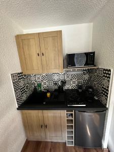 a small kitchen with a stove and a microwave at Chalet Puy-Saint-Vincent m from slopes in Puy-Saint-Vincent