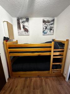 a wooden bunk bed in a room with pictures on the wall at Chalet Puy-Saint-Vincent m from slopes in Puy-Saint-Vincent