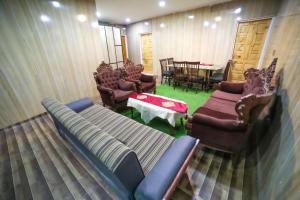 a living room with a couch and chairs and a table at Royal Brangsa in Skardu