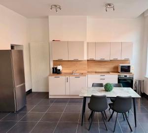 une cuisine avec une table, des chaises et un réfrigérateur dans l'établissement The2C, à Godshuis